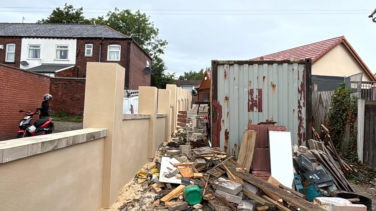 Long run of rendered garden walls and pillars along a back alley