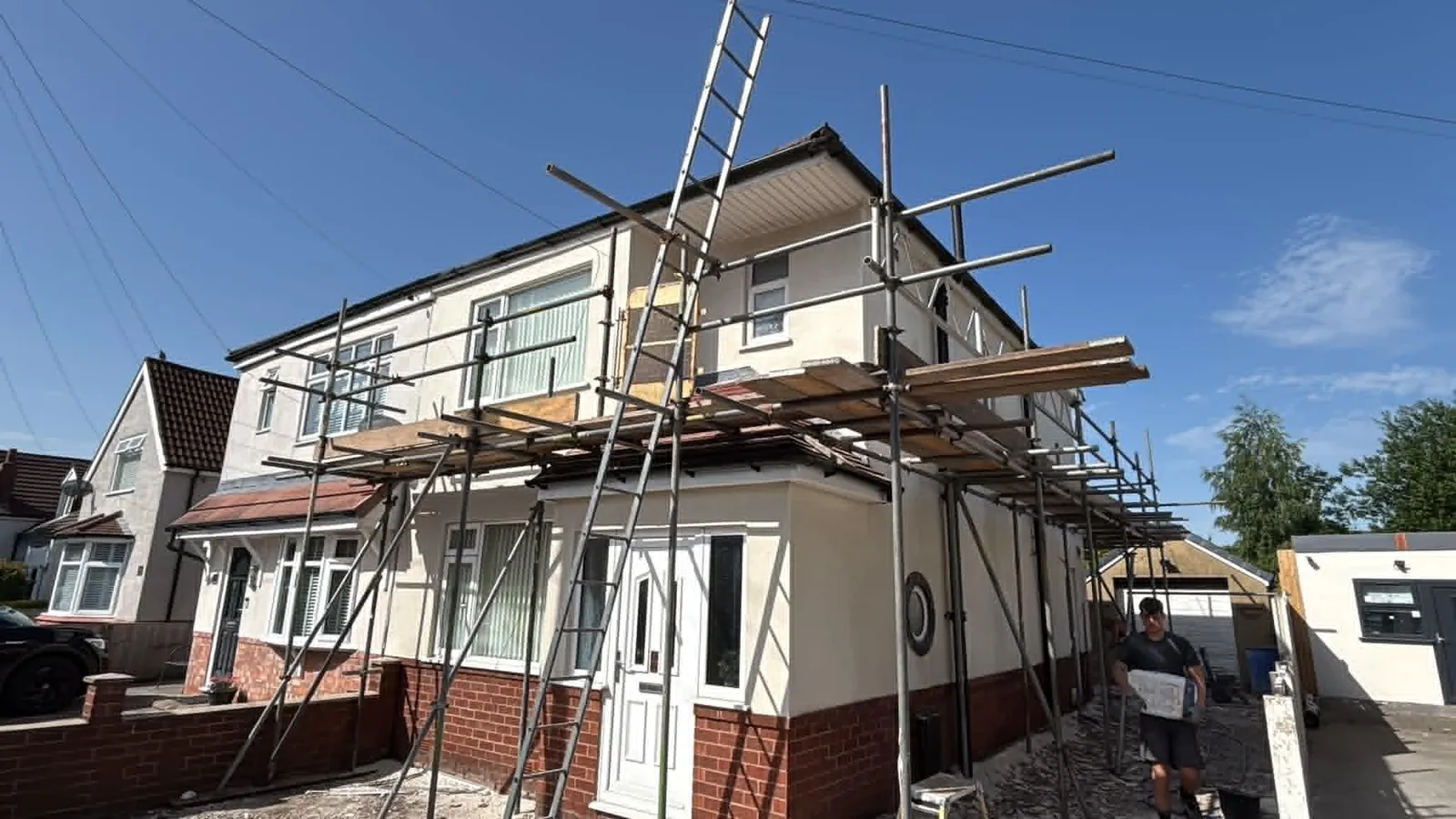 House rendering in progress on a semi-detached home with scaffold and ladders up