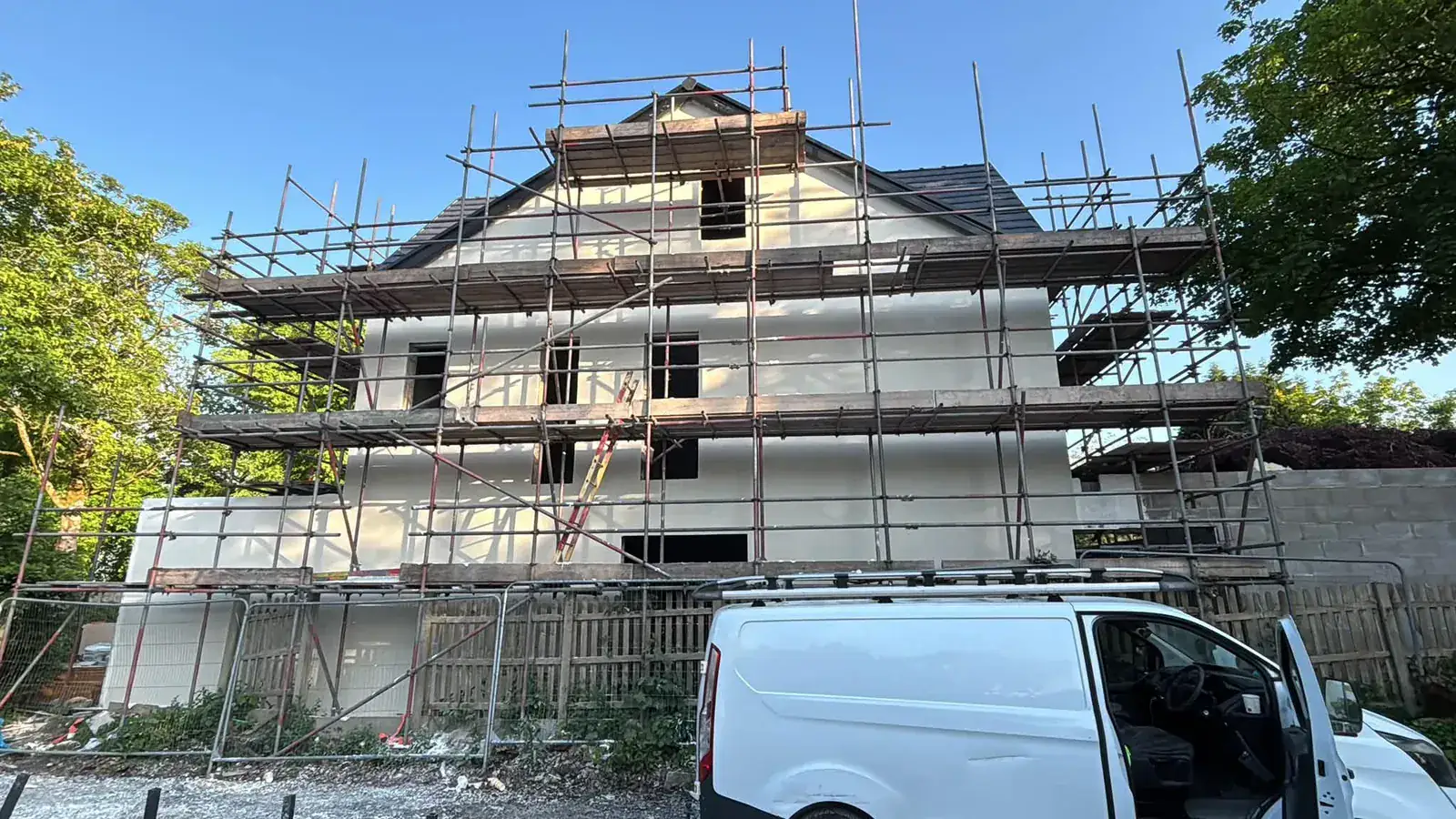 Fresh render on a three-storey gable elevation with scaffolding still up